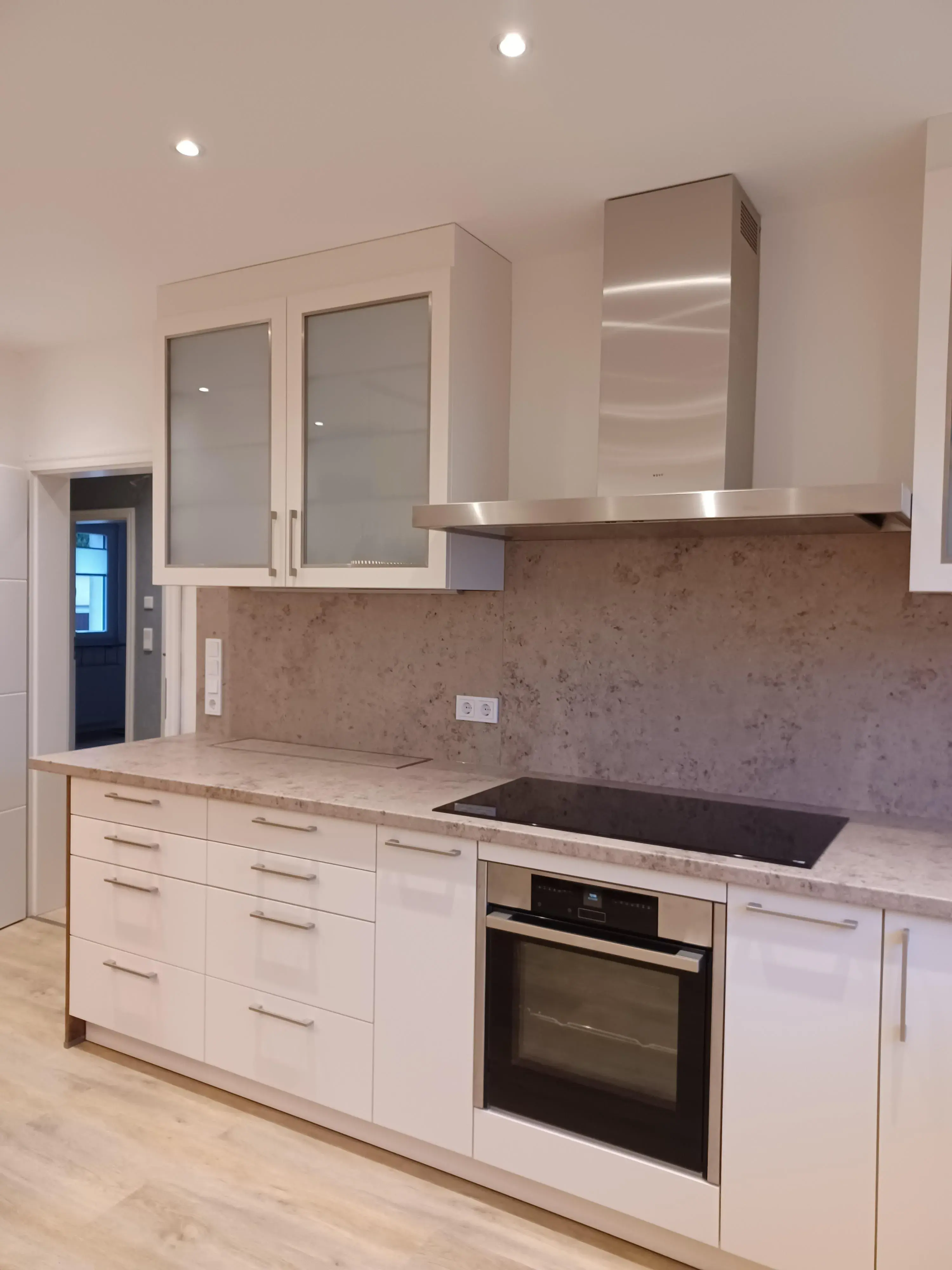 Moderne Einbauküche mit Herd, Backofen und hellen Schränken