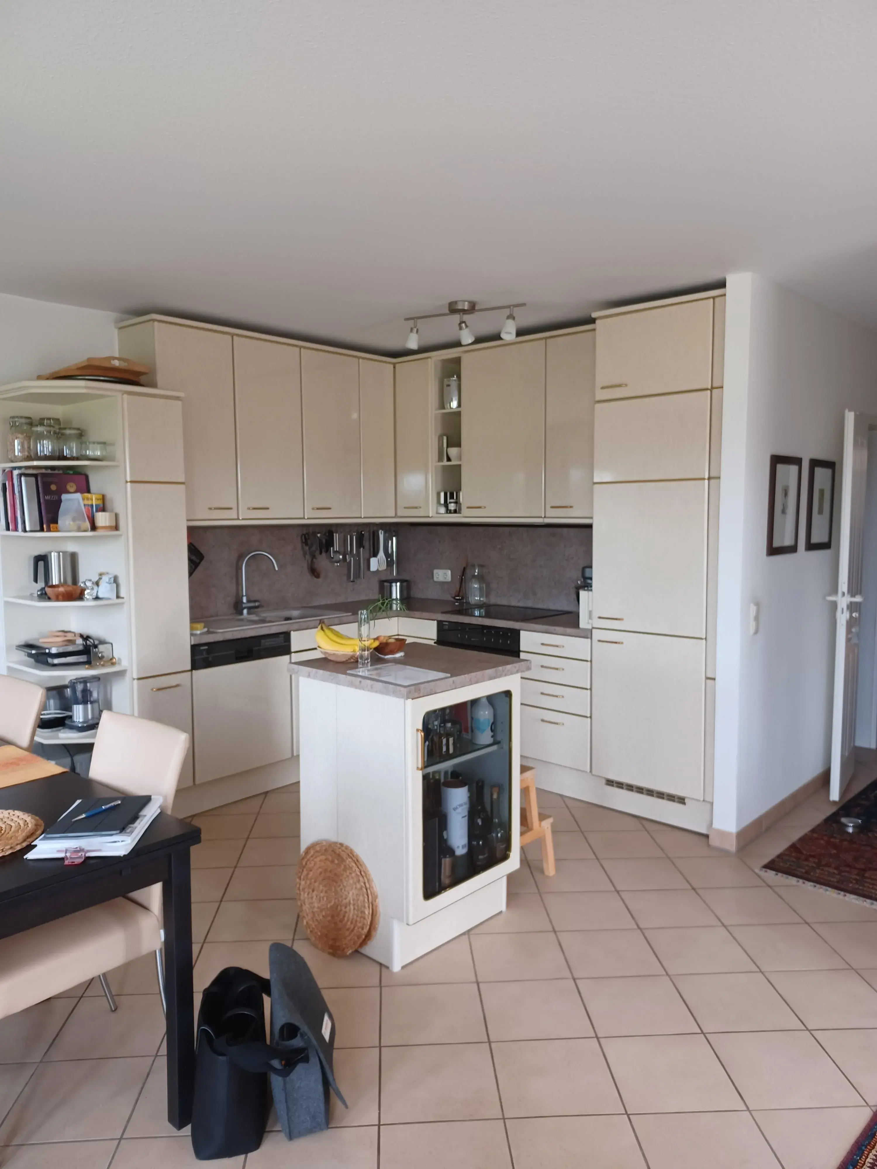 Helle, moderne Küche mit cremefarbenen Schränken und kleiner Kücheninsel.